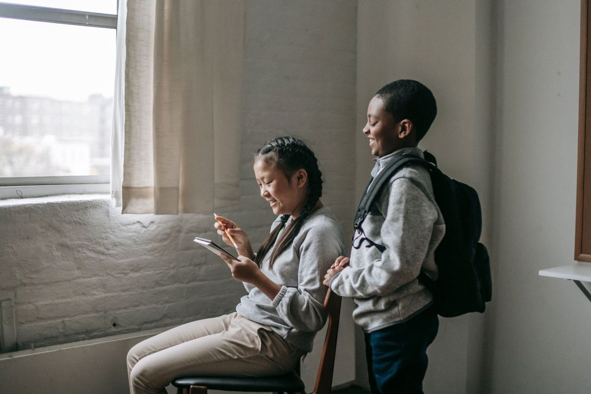 Dos estudiantes sonríen mientras usan una tablet